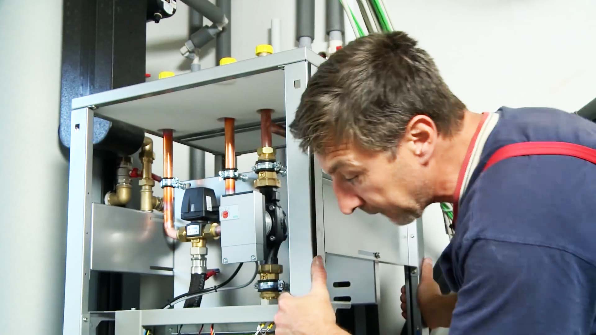 Elektroinstallation Wärmepumpe: Monteur installiert die Wärmepumpe inklusive Vorrichtung für den Wärmemengenzähler.