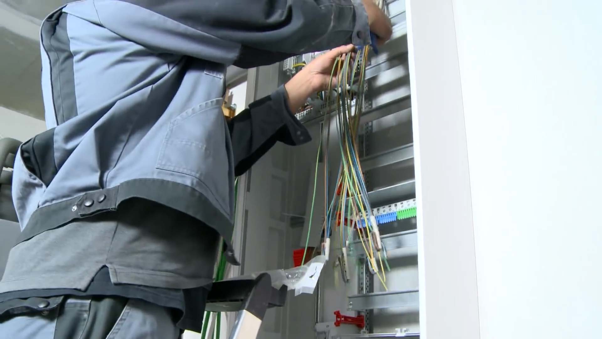 Elektroinstallation Wärmepumpe: Monteur baut den Verteilerkasten ein, der die Stromversorgung der Wärmepumpe und der Heizungsanlage zentral steuert.